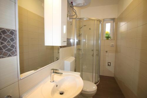 y baño con lavabo, ducha y aseo. en Apartment Noemi in city center, en Poreč