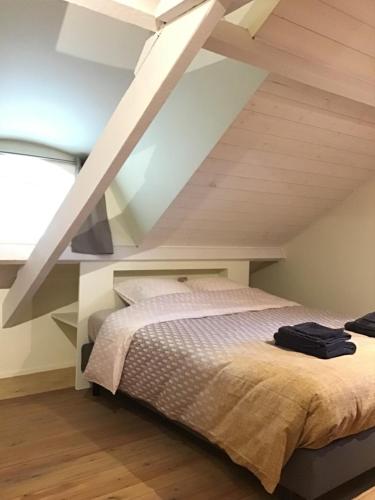 ein Schlafzimmer mit einem Bett im Dachgeschoss in der Unterkunft la maison du docteur in Heuvelland