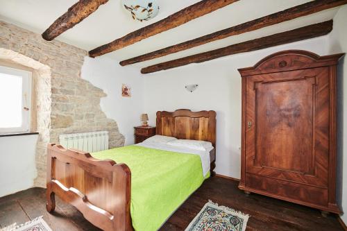 a bedroom with a wooden bed and a wooden cabinet at App Lidia in Grožnjan