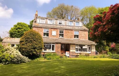 an old brick house on a green lawn at Elerkey Guest House in Veryan