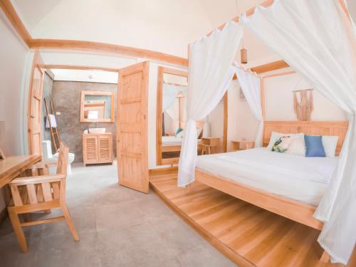 1 dormitorio con cama, escritorio y mesa en Bermuda Triangle Bungalows, en Siquijor