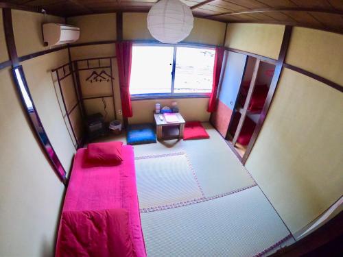 an overhead view of a small room with a pink bed at Benidaruma - Usagi in Kyoto