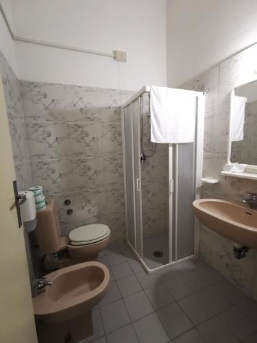 a bathroom with a toilet and a shower and a sink at Hotel Milani in Lido di Camaiore