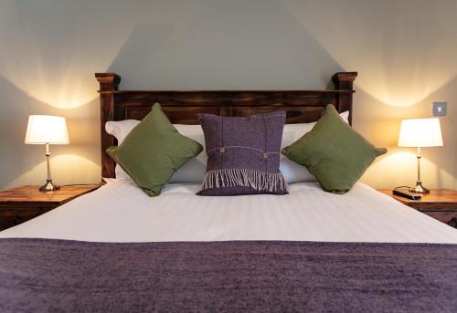 um quarto com uma cama com almofadas e 2 candeeiros em The Congresbury Arms em Congresbury