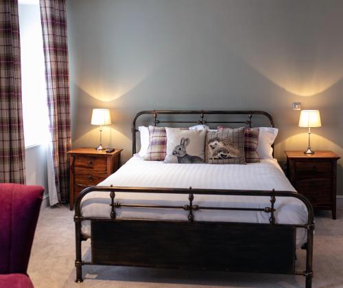 a bedroom with a bed with two lamps on tables at The Congresbury Arms in Congresbury