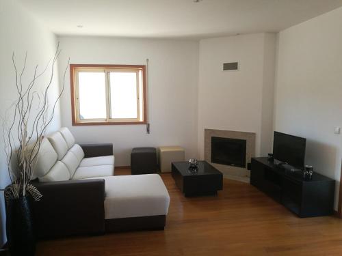a living room with a couch and a tv at Casa Carla in Guimarães