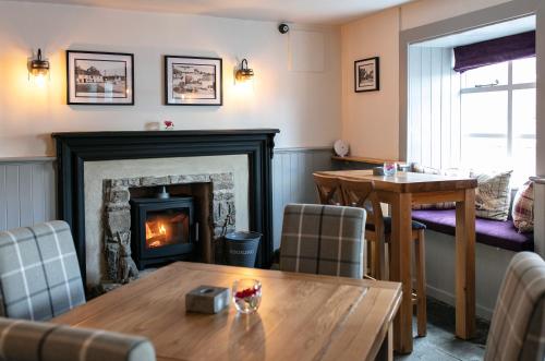 a living room with a fireplace and a table at The Congresbury Arms in Congresbury