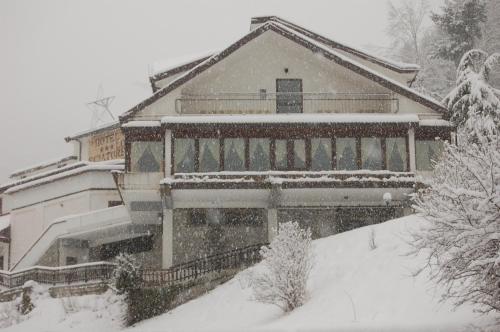 a house covered in snow in front at hotel lo sciatore in Cotronei
