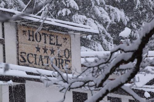 a sign for a hotel in the snow at hotel lo sciatore in Cotronei
