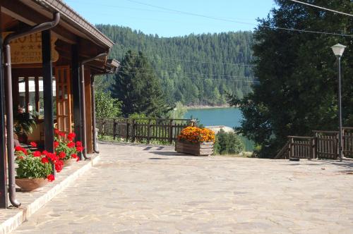 a porch of a building with flowers and a lake at hotel lo sciatore in Cotronei