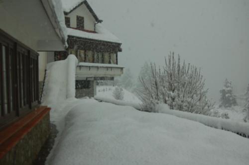 a yard covered in snow with a house at hotel lo sciatore in Cotronei