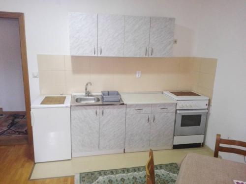 a small kitchen with white cabinets and a sink at Apartman Lazar in Vrnjačka Banja