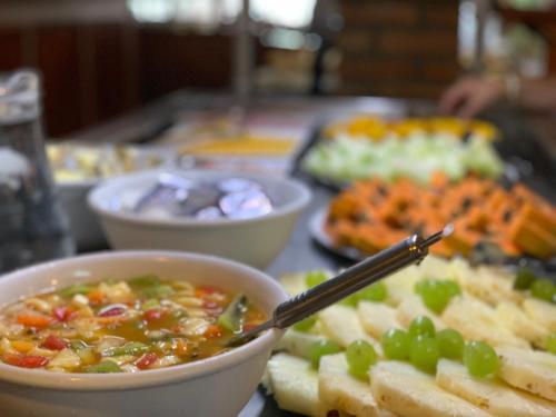 a table with a bowl of soup and grapes at Hotel São Sebastião da Praia in Florianópolis