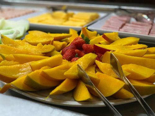 a plate of fruit on a table with spoons at Hotel São Sebastião da Praia in Florianópolis