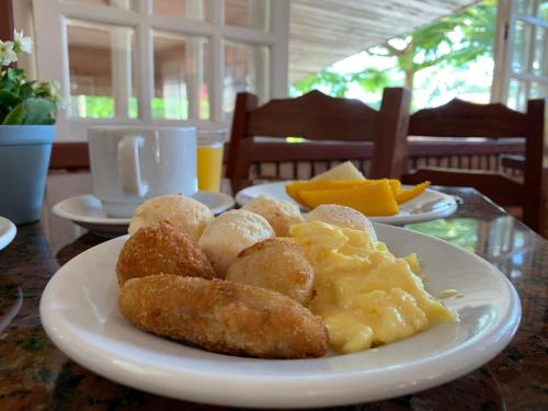 a plate of food on a table with potatoes and eggs at Hotel São Sebastião da Praia in Florianópolis