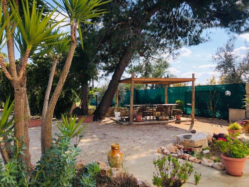 un giardino con gazebo e patio di B&B Terre dì Montecoco a San Pancrazio Salentino