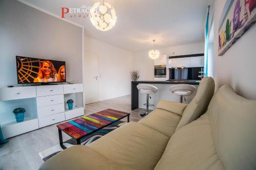 a living room with a couch and a tv at Comfort Apartment Oldenburg in Oldenburg