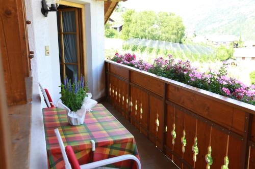 a balcony with a table and chairs and flowers at Fixlhof in Rifiano