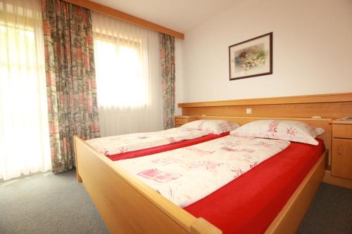 a bedroom with a large bed with a red blanket at Fixlhof in Rifiano