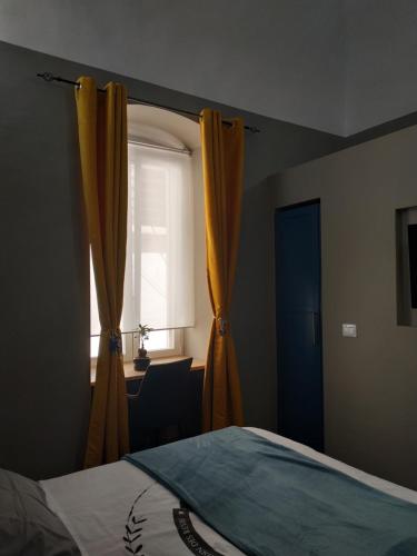 a bedroom with a window with yellow curtains and a bed at Suite 30 mq in Palo del Colle
