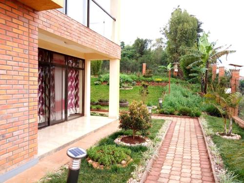 a brick building with a walkway next to a garden at Kigali Village Suites in Kigali