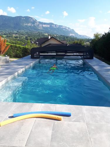 een persoon die zwemt in een zwembad bij Le Plein Soleil in Grésy-sur-Aix