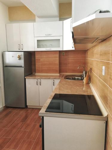 a kitchen with white cabinets and a stainless steel refrigerator at Vidojevski's Apartment in Ohrid
