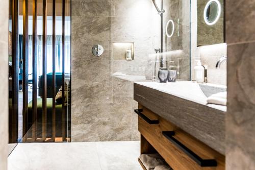 a bathroom with two sinks and a shower at Granbaita Dolomites in Selva di Val Gardena