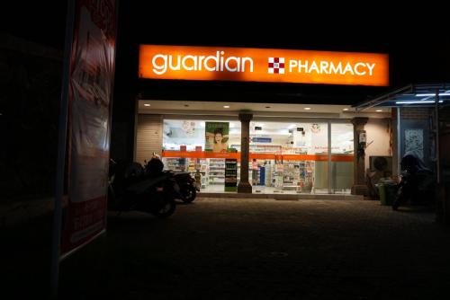 a motorcycle parked in front of a store at night at Louto Dmell Villa & Guesthouse in Sanur