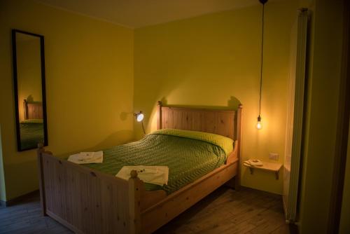 a bedroom with a bed with a green comforter at Helvetia Bed & Breakfast in Castelmezzano