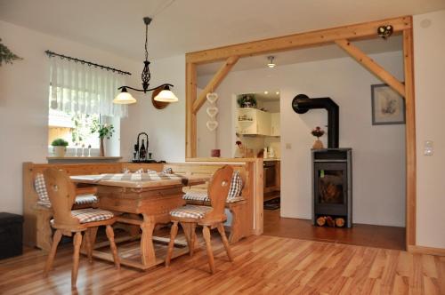 una cucina e una sala da pranzo con tavolo e sedie in legno di Ferienwohnung Ruhepol a Bichel