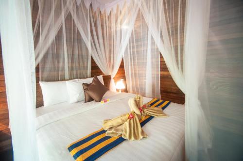 une chambre avec un lit blanc avec des serviettes dessus dans l'établissement Ruji Ananta Cottage, à Nusa Penida