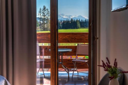a sliding glass door with a view of a porch at Apartamenty, pokoje PRZY TERMACH - 70 m Termy Szaflary, 150 m Gorący Potok in Szaflary