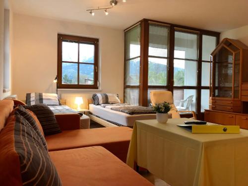 uma sala de estar com um sofá e uma mesa em Ferienwohnung-Apartment Monika in Innsbruck-Igls em Innsbruck