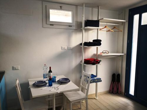 a dining room with a table and chairs and a shelf at Framavi Beach in Cefalù