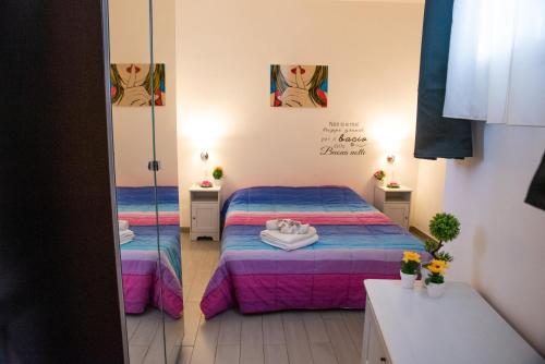アグリジェントにあるAttico Panoramico Agrigentoの小さな部屋で、ベッド2台、鏡が備わります。