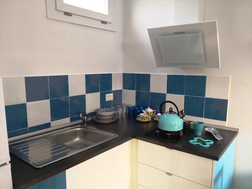 a kitchen with a sink and a stove with a tea kettle at Framavi Beach in Cefalù