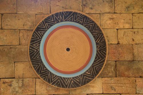 a bowl on a plate on a brick floor at Linda casa em Itacaré Bahia in Itacaré