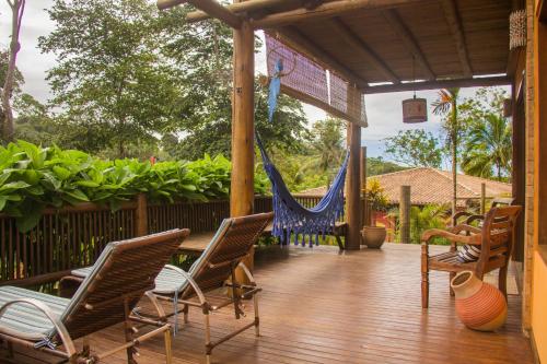 a porch with chairs and hammocks on a house at Linda casa em Itacaré Bahia in Itacaré