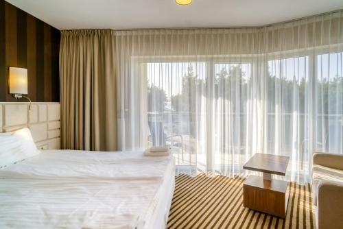a hotel room with a bed and a large window at Hotel White in Krynica Morska