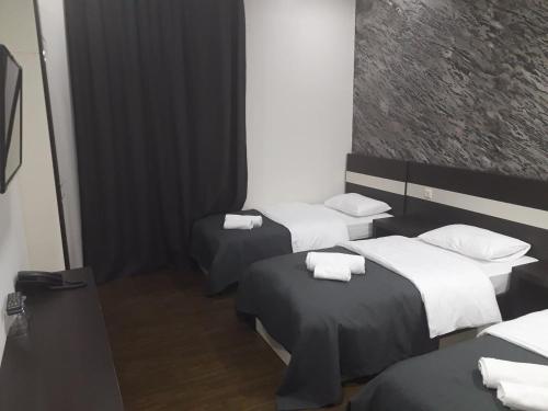 a room with three beds with towels on them at West Tower Hotel in Kutaisi