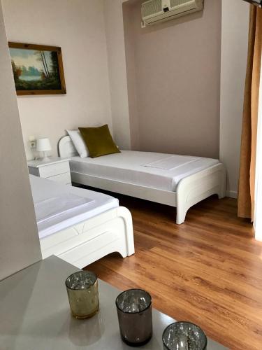 a living room with two white beds and a table at Joy Hotel in Sarandë