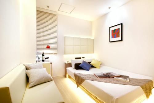 ein weißes Schlafzimmer mit einem Bett und einem Stuhl in der Unterkunft Hotel DUO kinsicho in Tokio