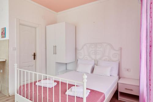 a white bedroom with a white bed and a white cabinet at Apartments Barbara in Kotor