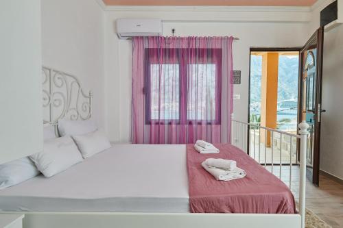 a bedroom with a white bed with a pink window at Apartments Barbara in Kotor
