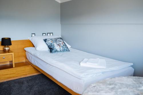 a white bed with a pillow on it in a room at Hotel GH Kolinska in Bled