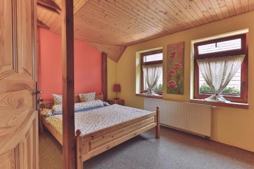 a bedroom with a bed and two windows at Holiday Resort Švárny in Ružomberok