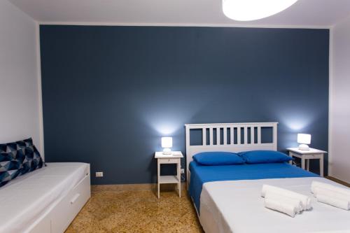 a bedroom with two beds and a blue wall at Villa Aurora Mondello Addaura in Mondello