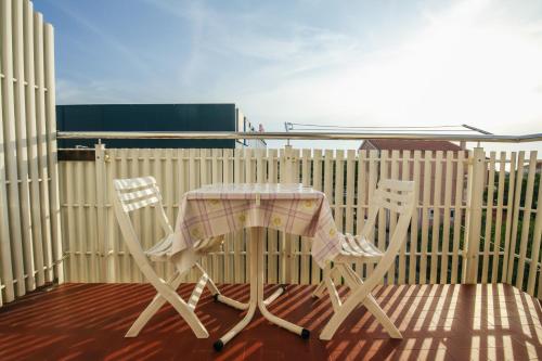 a table and two chairs on a balcony at Apartments & Rooms Peranic in Novalja