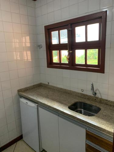 a kitchen with a sink and a window at Hotel São Sebastião da Praia in Florianópolis